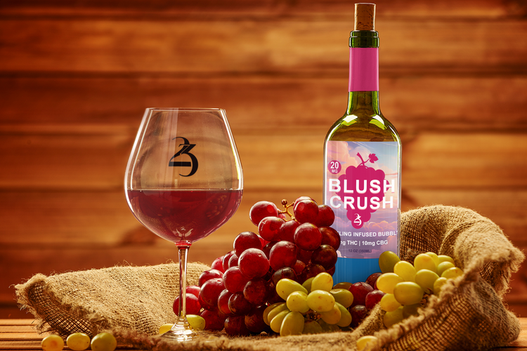 Bottle of Blush Crush wine with a glass and grapes on a wooden surface