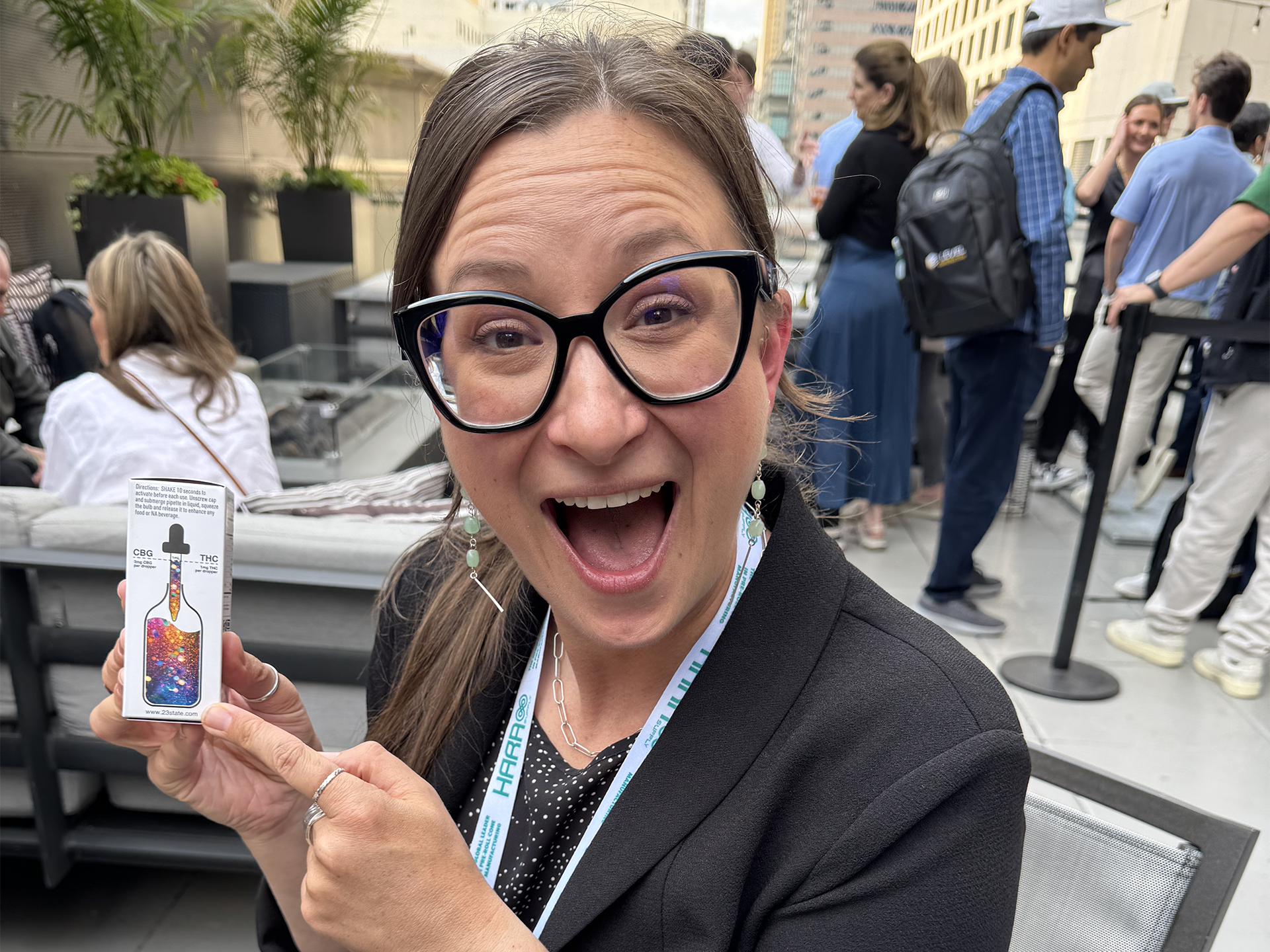 Woman holding a SHAKE product packaging on a rooftop patio.