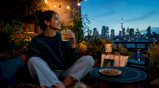 Person enjoying hemp beverage on rooftop at sunset