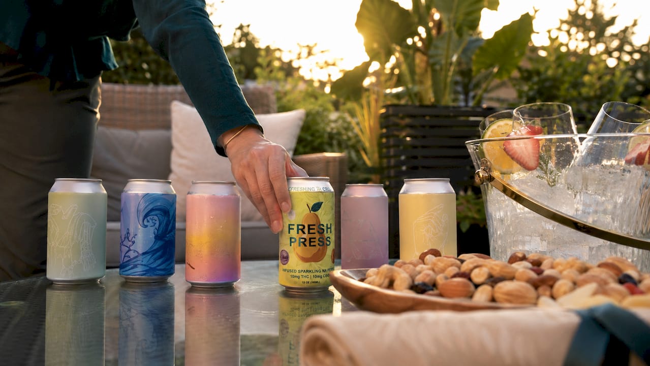 Hemp THC beverage cans on brunch table with hand
