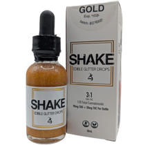 Bottle and packaging of 24k Shake Edible THC infused Glitter Drops with 'Gold' label on a white background